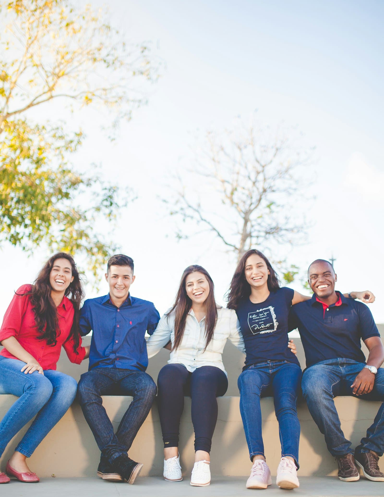 Smiling members of the DOREDU community sitting together outdoors